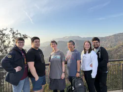 Mallory and Tynor's family in front of a distant Hollywood sign
